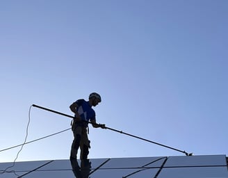 a man on a roof top with a pole pole