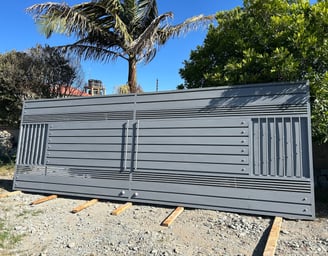 a large metal fenced in area with a palm tree