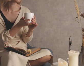 a woman sitting on a chair holding a cup of coffee