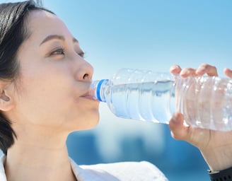 woman drinking water out of a bottle
