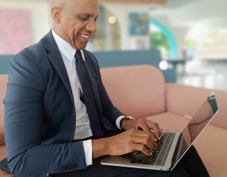 « Bruno Valery concentré sur son ordinateur dans le lobby élégant d’un hôtel 4 étoiles en Guadeloupe »