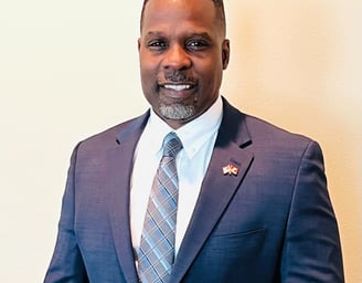 Dr. Marlon Ware professional headshot in blue suit with blue striped tie