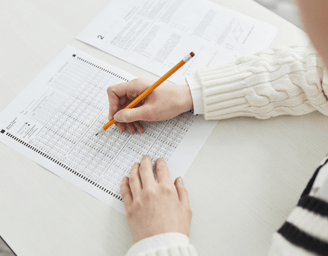 Person filling out an exam sheet during a hoof trimming course.