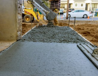 a man is pouring concrete into a concrete slab