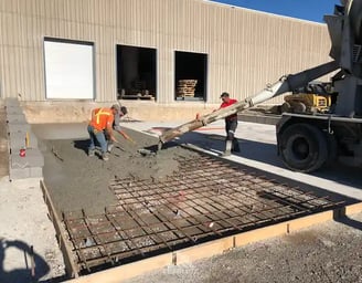 a man is pouring concrete into a concrete slab