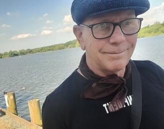 Rob Hamilton walking by a lake, smiling