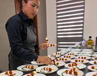 a woman in a chef's apron preparing food