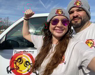 a man and woman standing in front of a truck after an old appliance pickup