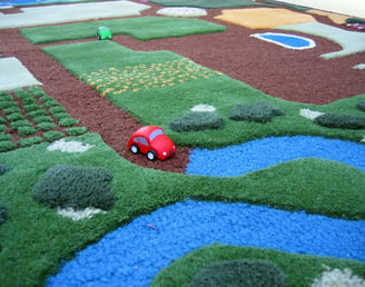 Wooden toy car on woolen play carpet