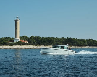 Just enjoy boat cruising the waves, passing by a lighthouse on the shore.