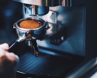 a person is making a coffee in a coffee machine