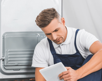 a man in a blue apron and a tablet computer