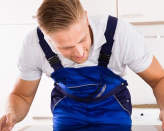 a man in a blue overalls and a white shirt
