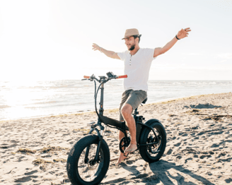 a man riding a bike on a beach
