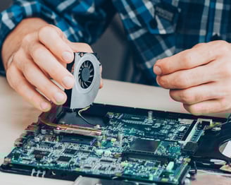 a man is repairing a computer motherboard