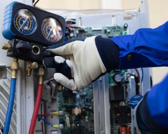 a person in a blue jacket and gloves holding a hose and a hose