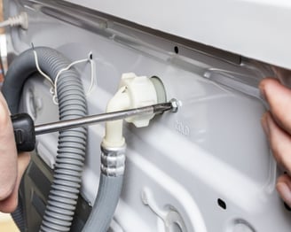 a person is fixing a dishwasher in a kitchen