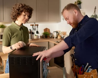 a man and woman standing in a kitchen