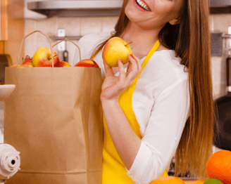 a woman holding a paper bag with apples and apples