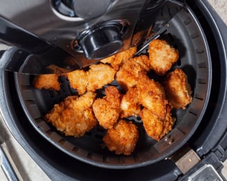 a fryer with chicken nuggling in it