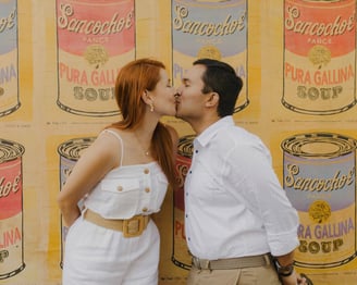Pareja besandose frente a una pared con arte