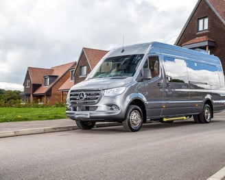 16 seater silver van parked on the side of a road