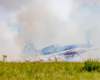 a plane is flying low over a grassy area