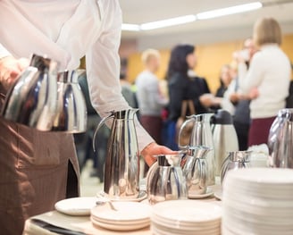 a waitress's hand is holding a tray with plates and cups
