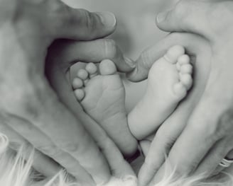 a baby's feet and hands holding a baby's feet