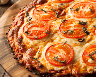 a vegan pizza with tomatoes and cheese on a wooden board