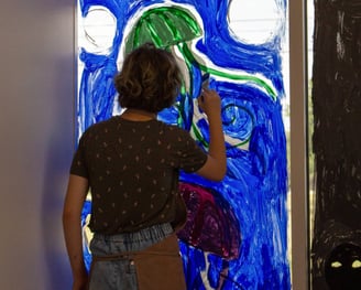 Young teen painting jellyfish on the window of our studio.