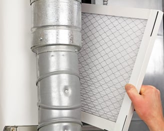 a person holding a duct with a air filter