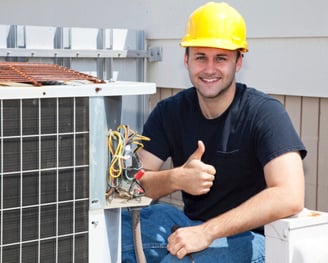 a man in a hard hat and a yellow helmet fixing a broken air conditioning unit