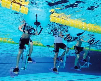 uomini che svolgono esercizi con cyclette in piscina