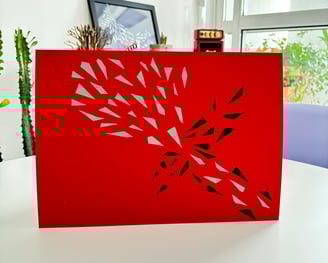 arte em fita isolante prata e preta sobre papel vermelho.