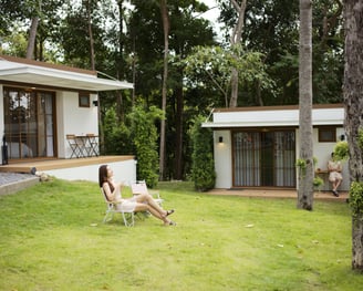 a woman sitting in a lawn chair in a front-yard green carpeted (grass) lawn, of The Boulder Phangan