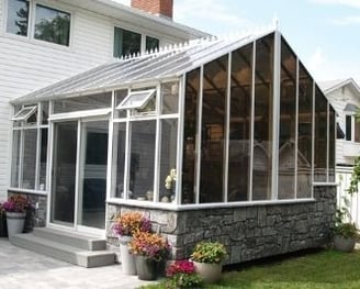 Gable Solarium or Peaked Solarium with faux stone pony wall, roof crests and sliding door.