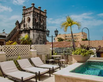 a pool with lounge chairs and a clock tower