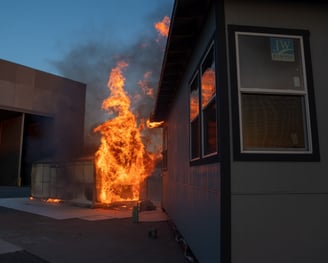 IBHS research center testing fire prevention for properties showing an engulfed structure next to another building catch fire