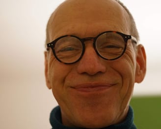a man with glasses and a blue sweater