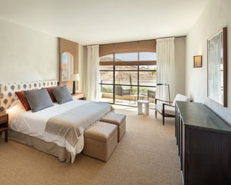 Bright bedroom suite at Villa La Gratitud with garden views, cozy seating, and soft natural tones.