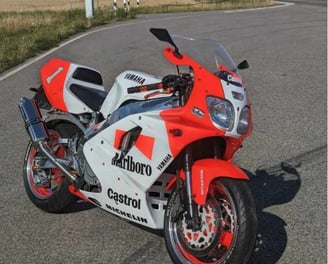 Bild von einem Motorad, rot und weiße Farbe, mit verschiedenen Schriftzügen