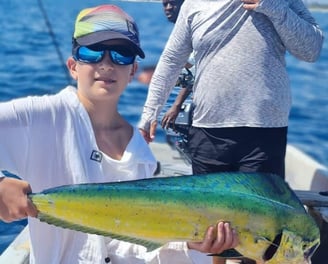 Young angler with a dorado fish on a Zanzibar Catamaran Fishing Charter