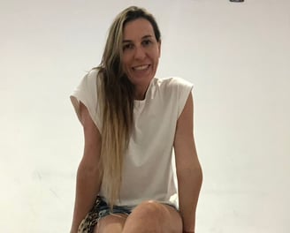 a woman sitting on a pile of rolls of toilet paper