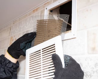 a person wearing gloves and gloves is cleaning a vent vent venting