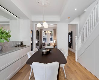 Dining room beside traditional Victorian timber staircase with central pendant light, wall mirror