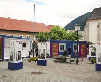 Besucher erkunden die Außenanlage der mobilen Ausstellung "Aus weg los!".