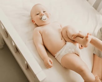 Una persona ayudando a un bebe con ejercicios de fisioterapia para displasia de cadera