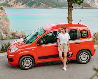 a woman standing next to a red van