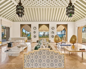 Living room at Villa El Rincon in Marbella featuring sea views, elegant décor, and floor-to-ceiling windows.